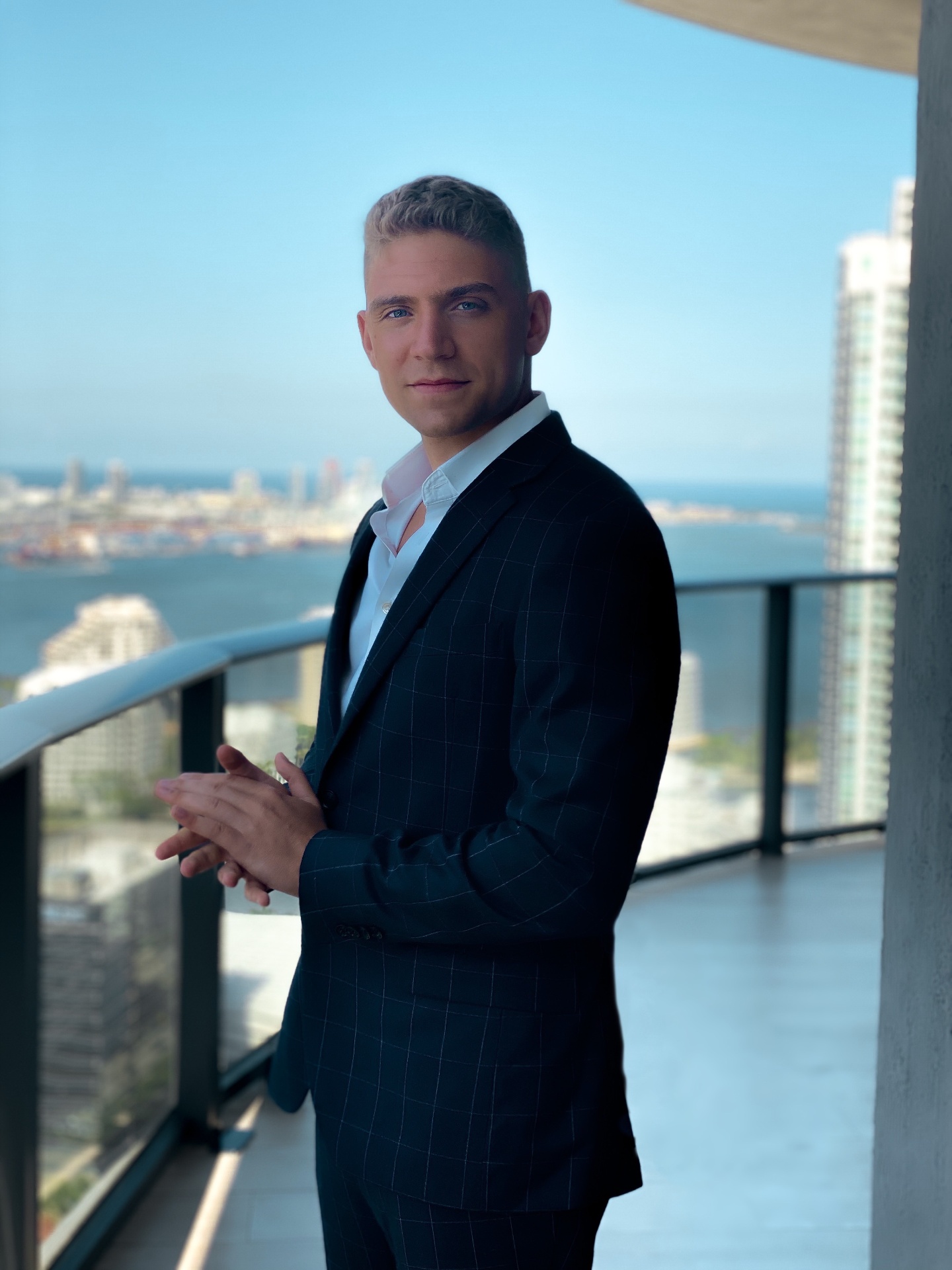Founder of Flexx Mortgage on a Brickell, Miami balcony overlooking Biscayne Bay